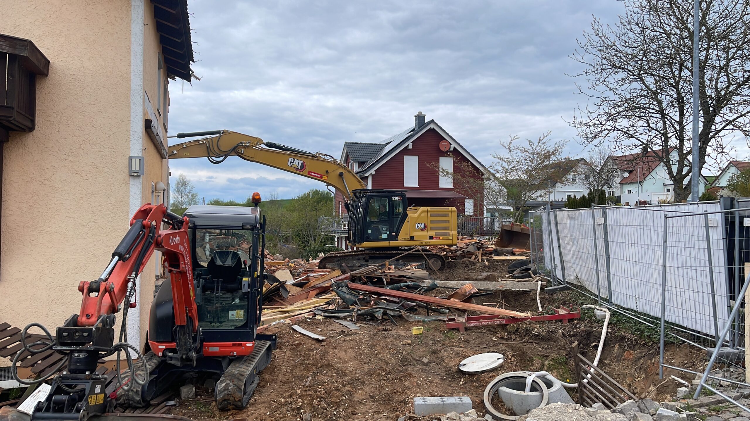 Abrissarbeiten mit Bagger vor Wohnhaus